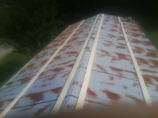Rusted metal roof panels with new wood purlins before replacement — Storm Damage Roof Repair in Hillpoint by Roofing Brothers