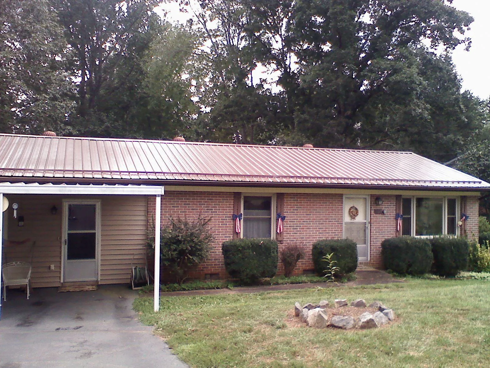 Bronze metal roof and carport on a brick ranch home — Roof Repair work by our crew in Hillpoint