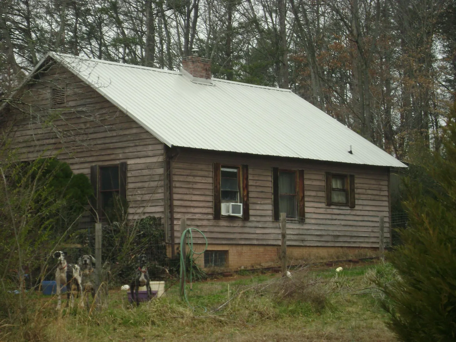 White metal roof on an old wood sided farmhouse, from a Metal Roof Installation job in Hillpoint